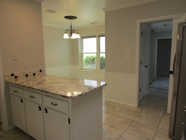 3109 Dallas St NE, Albuquerque, NM 87110 - kitchen with a peninsula, white cabinetry, freestanding refrigerator, crown molding, and light tile patterned floors