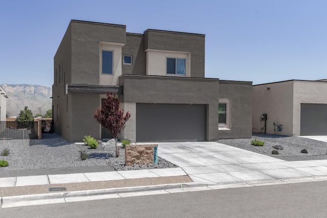 4381 Lauren Loop NE, Rio Rancho, NM 87124 - contemporary house featuring driveway, stucco siding, a garage, and a mountain view