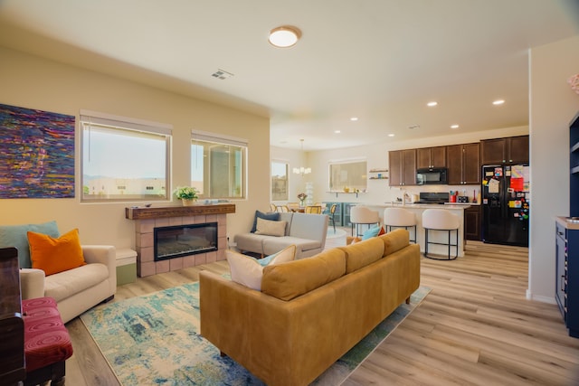 4381 Lauren Loop NE, Rio Rancho, NM 87124 - living room featuring recessed lighting, light wood-type flooring, and a fireplace