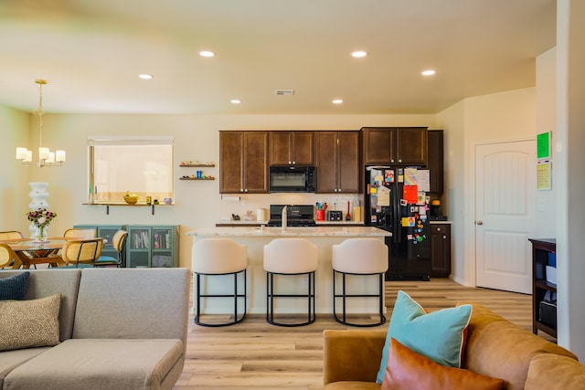 4381 Lauren Loop NE, Rio Rancho, NM 87124 - kitchen with black appliances, a chandelier, dark brown cabinetry, open floor plan, and light wood finished floors