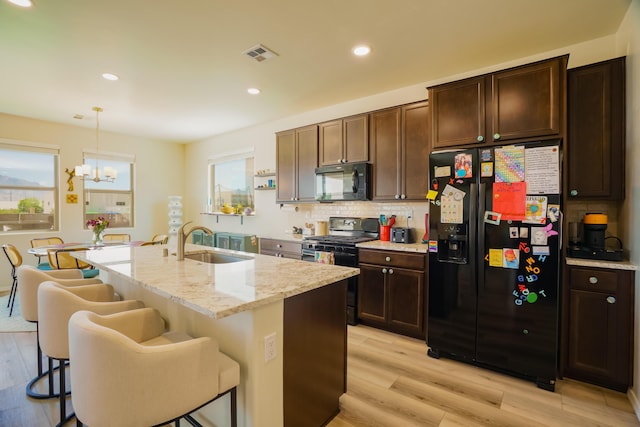 4381 Lauren Loop NE, Rio Rancho, NM 87124 - kitchen with black appliances, a chandelier, healthy amount of natural light, light wood-style floors, and recessed lighting