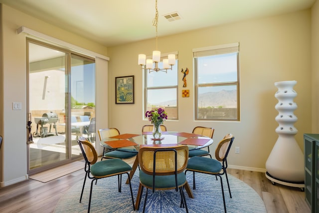 4381 Lauren Loop NE, Rio Rancho, NM 87124 - dining area with plenty of natural light, a chandelier, and wood finished floors