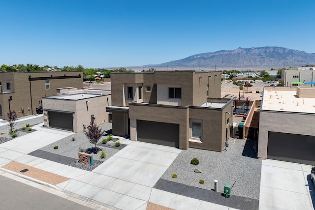 4381 Lauren Loop NE, Rio Rancho, NM 87124 - view of front of house featuring stucco siding, a mountain view, driveway, and a garage