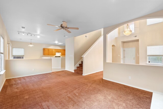 10431 Crosscut Dr NW, Albuquerque, NM 87114 - unfurnished living room featuring light colored carpet, ceiling fan, arched walkways, and stairway