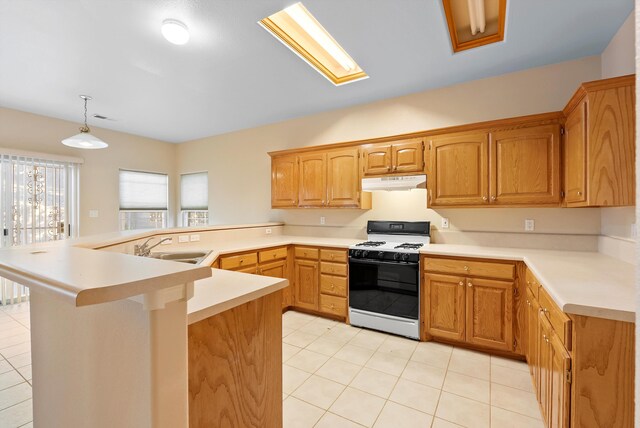 10431 Crosscut Dr NW, Albuquerque, NM 87114 - kitchen featuring gas range, under cabinet range hood, a peninsula, light tile patterned flooring, and light countertops