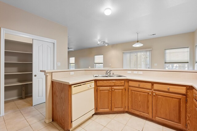 10431 Crosscut Dr NW, Albuquerque, NM 87114 - kitchen with white dishwasher, light countertops, light tile patterned flooring, and brown cabinets