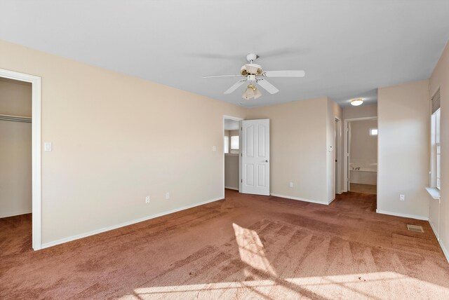 10431 Crosscut Dr NW, Albuquerque, NM 87114 - unfurnished bedroom with carpet floors, a spacious closet, connected bathroom, and a ceiling fan