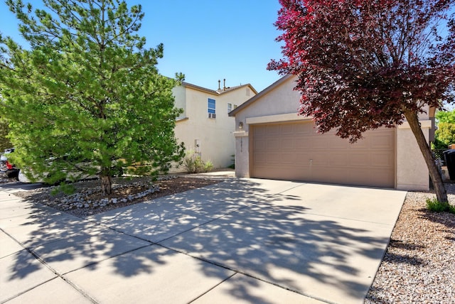 10636 Mcmichael Ln SW, Albuquerque, NM 87121 - obstructed view of property with stucco siding, a garage, and driveway