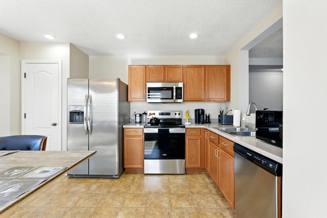 10636 Mcmichael Ln SW, Albuquerque, NM 87121 - kitchen featuring stainless steel appliances, light countertops, recessed lighting, a textured ceiling, and brown cabinets