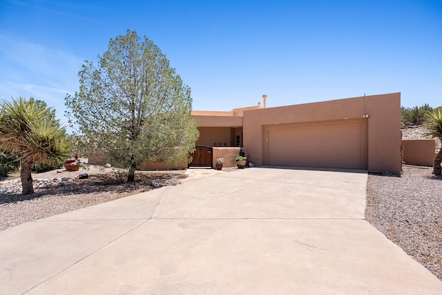 3 Seasons Cir, Placitas, NM 87043 - pueblo revival-style home featuring stucco siding, a garage, and driveway