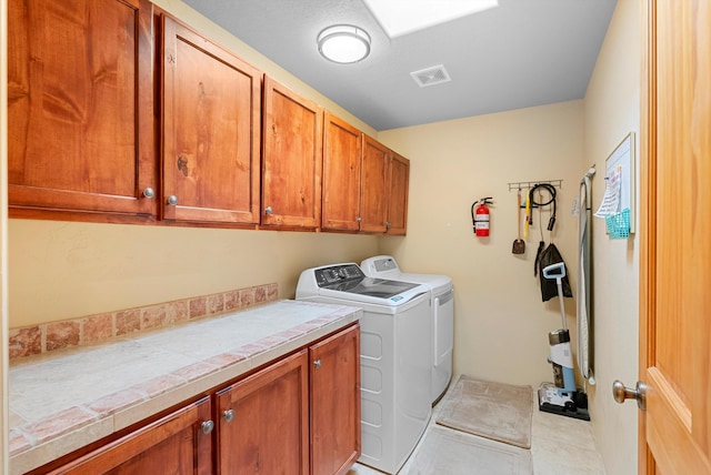 3 Seasons Cir, Placitas, NM 87043 - laundry area featuring cabinet space, washer and clothes dryer, and light tile patterned floors