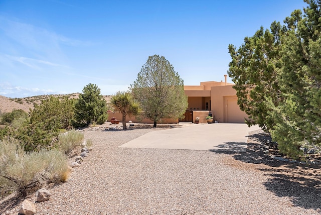 3 Seasons Cir, Placitas, NM 87043 - view of front of house with stucco siding, a garage, and driveway