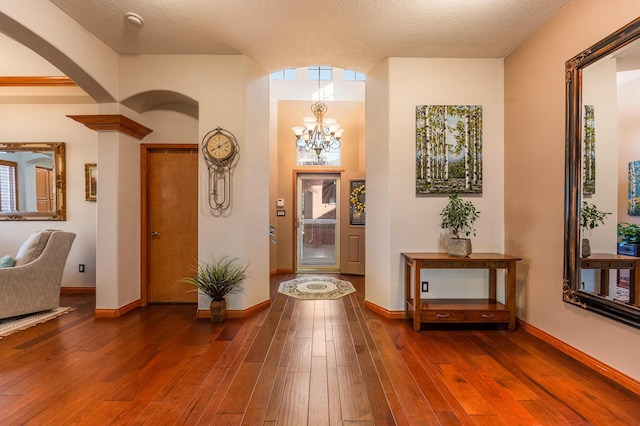 924 Seattle Slew Ave SE, Albuquerque, NM 87112 - foyer entrance with arched walkways, dark wood-style flooring, and a chandelier