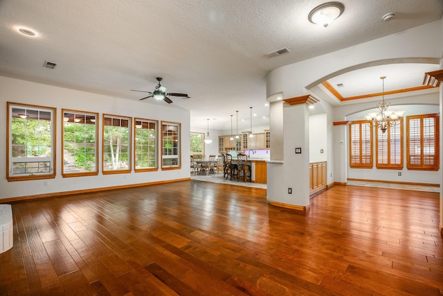 924 Seattle Slew Ave SE, Albuquerque, NM 87112 - unfurnished living room with a ceiling fan, wood-type flooring, a chandelier, arched walkways, and a textured ceiling