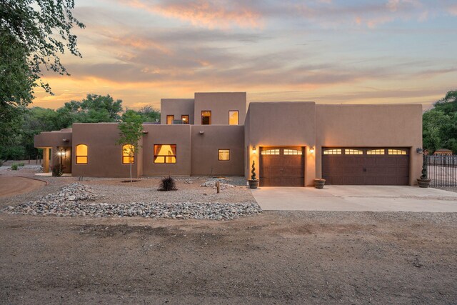 9005 4th St NW, Albuquerque, NM 87114 - pueblo-style house featuring an attached garage, concrete driveway, and stucco siding