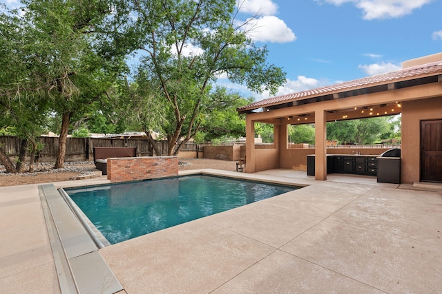 9005 4th St NW, Albuquerque, NM 87114 - view of swimming pool featuring a patio area, a fenced backyard, and exterior kitchen