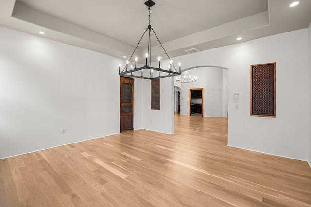 9005 4th St NW, Albuquerque, NM 87114 - unfurnished dining area featuring recessed lighting, arched walkways, a raised ceiling, light wood finished floors, and a chandelier