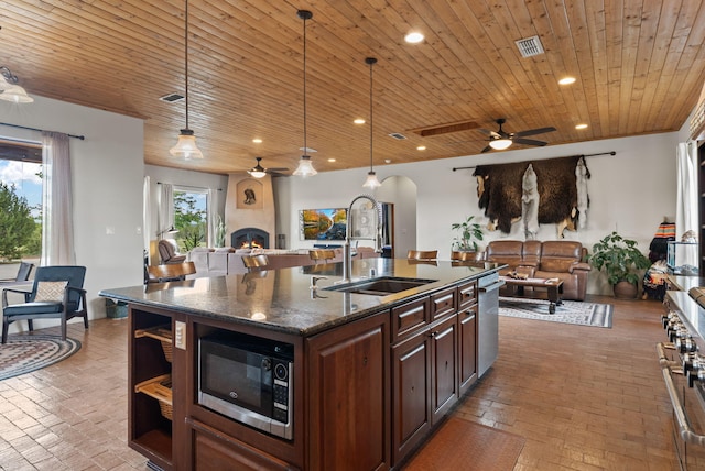 168 Lesperance Rd, Estancia, NM 87016 - kitchen featuring stainless steel appliances, open floor plan, ceiling fan, brick flooring, and wooden ceiling