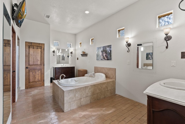 168 Lesperance Rd, Estancia, NM 87016 - bathroom featuring two vanities, a garden tub, and brick patterned floors