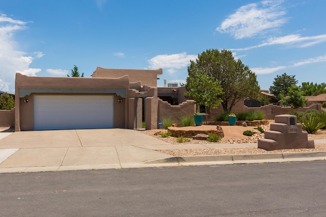 6816 Tamarisk Pl NW, Albuquerque, NM 87120 - adobe home with concrete driveway, an attached garage, and stucco siding