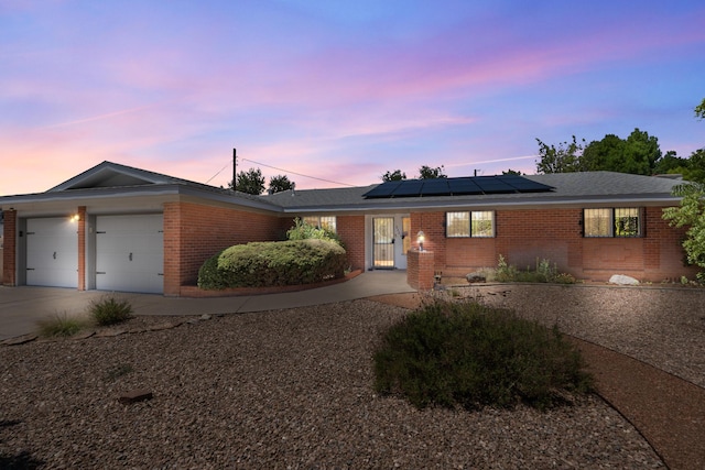 2331 Morrow Rd NE, Albuquerque, NM 87106 - ranch-style home featuring brick siding, solar panels, and a garage