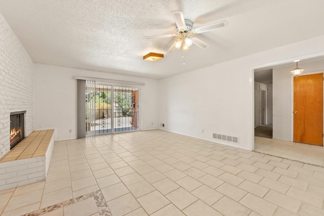 2331 Morrow Rd NE, Albuquerque, NM 87106 - unfurnished living room with a ceiling fan, a textured ceiling, a brick fireplace, and light tile patterned flooring