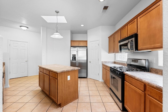 3912 Tundra Swan Ct NW, Albuquerque, NM 87120 - kitchen featuring stainless steel appliances, a skylight, a center island, brown cabinetry, and light tile patterned floors