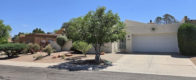 6700 Vista Del Monte NE, Albuquerque, NM 87109 - pueblo-style home featuring driveway, an attached garage, and stucco siding
