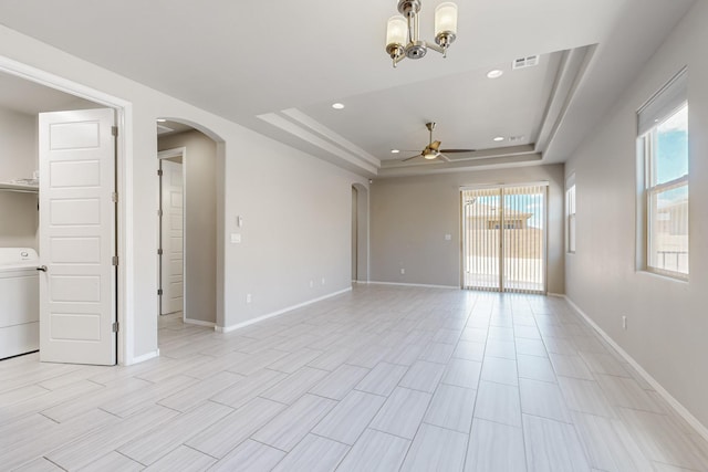 415 Adeline Ave, Los Lunas, NM 87031 - empty room featuring arched walkways, a ceiling fan, a tray ceiling, washer / dryer, and recessed lighting