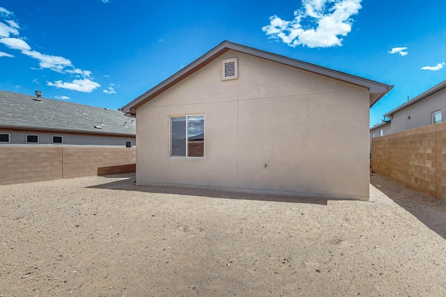 415 Adeline Ave, Los Lunas, NM 87031 - back of property with a fenced backyard, stucco siding, and a patio