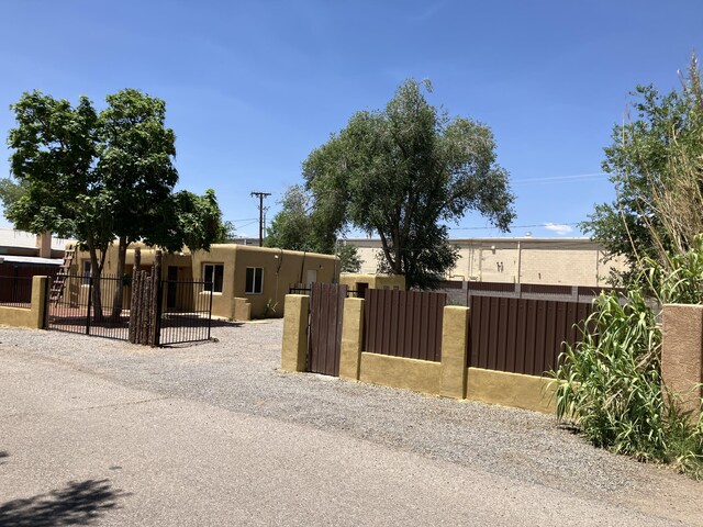 3107 Draxton Ave SW, Albuquerque, NM 87105 - pueblo-style home with a fenced front yard, a gate, and stucco siding