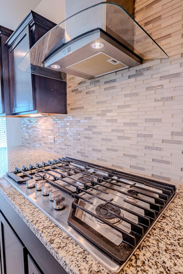 4289 Crowned Eagle Loop NE, Rio Rancho, NM 87144 - kitchen view of stainless steel gas cooktop, island exhaust hood, backsplash, and light stone counters