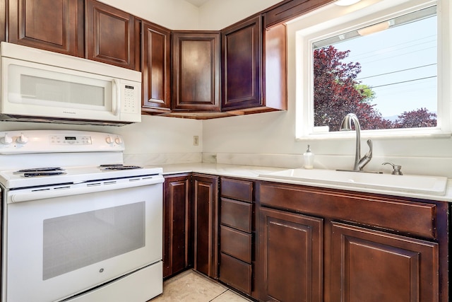 2600 Virginia St NE, Albuquerque, NM 87110 - kitchen with white appliances, light countertops, light tile patterned floors, and dark brown cabinets