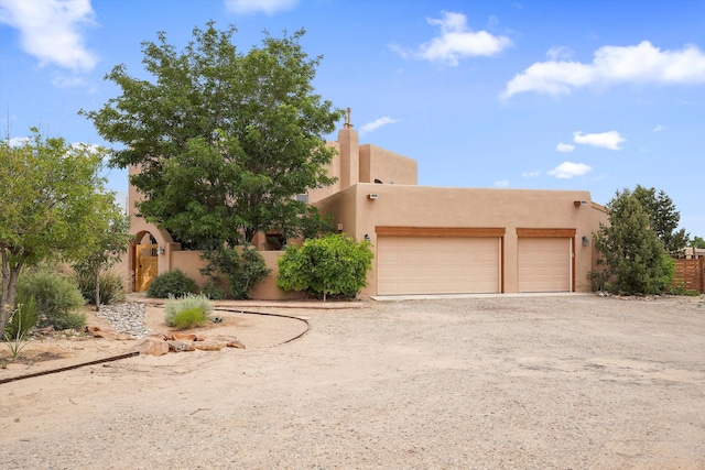651 Calle De Blas, Corrales, NM 87048 - pueblo-style home featuring stucco siding, driveway, and an attached garage