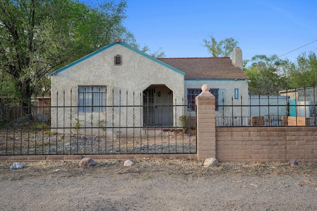 1233 Montrose Pl SW, Albuquerque, NM 87105 - view of front of home with a chimney, stucco siding, a fenced front yard, and roof with shingles