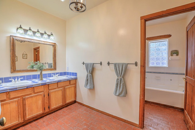 78 Quirks Ln, Corrales, NM 87048 - full bathroom featuring brick floors, double vanity, a chandelier, and a bath
