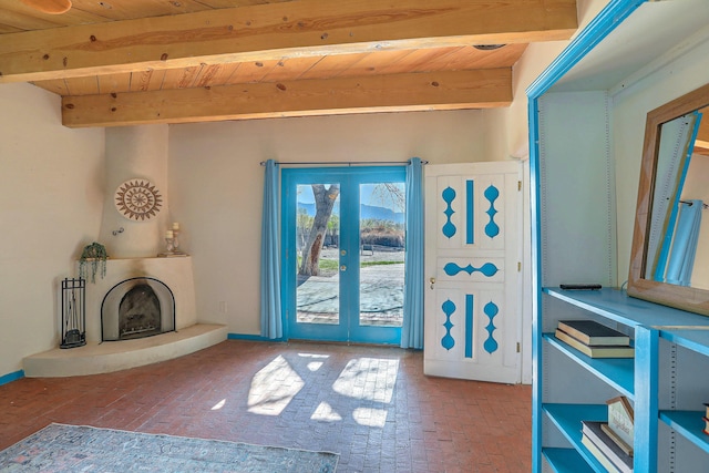 78 Quirks Ln, Corrales, NM 87048 - entryway with brick flooring, a wood ceiling with exposed beams, and a fireplace