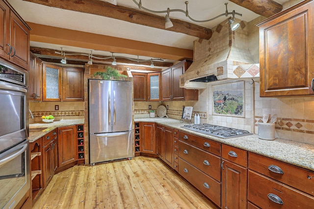 78 Quirks Ln, Corrales, NM 87048 - kitchen with appliances with stainless steel finishes, beam ceiling, light wood-style flooring, backsplash, and light stone countertops