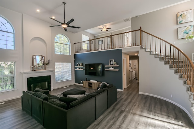 6109 Chamblee Ct NE, Albuquerque, NM 87111 - living room featuring ceiling fan, a towering ceiling, a glass covered fireplace, wood finished floors, and stairway