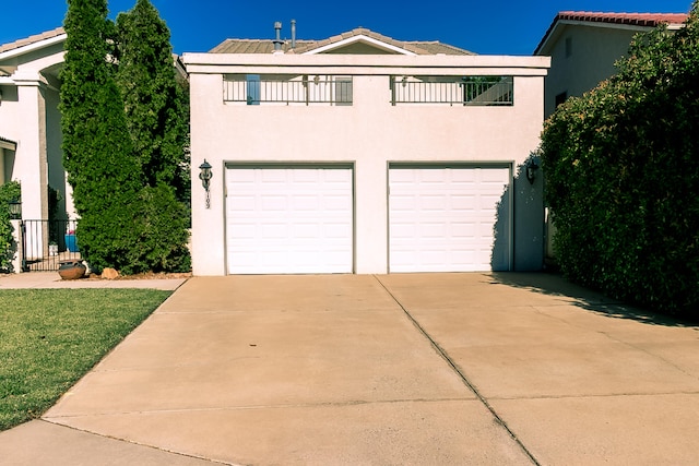 6109 Chamblee Ct NE, Albuquerque, NM 87111 - view of front of house with an attached garage, concrete driveway, stucco siding, and a balcony