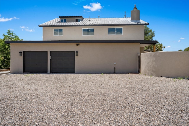 7 Corte De Canoncito, Cedar Crest, NM 87008 - back of house featuring stucco siding, a chimney, a metal roof, gravel driveway, and a garage
