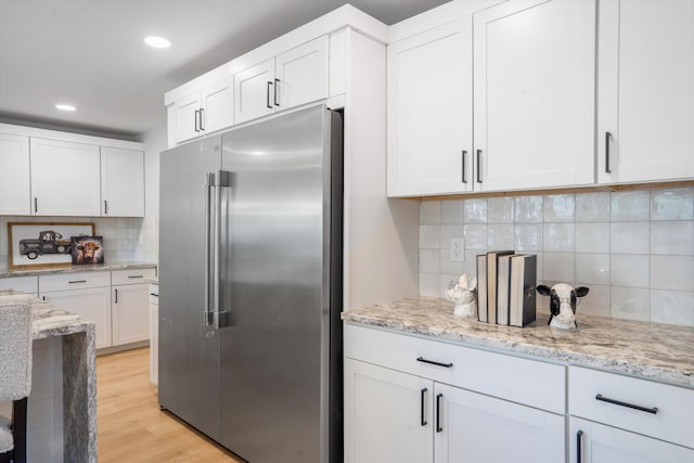 7 Corte De Canoncito, Cedar Crest, NM 87008 - kitchen with high end fridge, backsplash, white cabinets, light stone counters, and recessed lighting