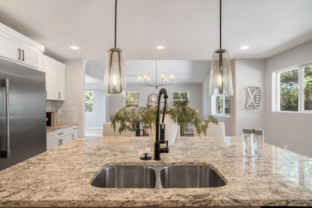 7 Corte De Canoncito, Cedar Crest, NM 87008 - kitchen with stainless steel fridge, light stone counters, white cabinetry, recessed lighting, and decorative light fixtures