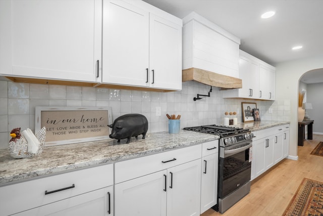 7 Corte De Canoncito, Cedar Crest, NM 87008 - kitchen featuring stainless steel gas range oven, arched walkways, light wood-type flooring, white cabinetry, and recessed lighting