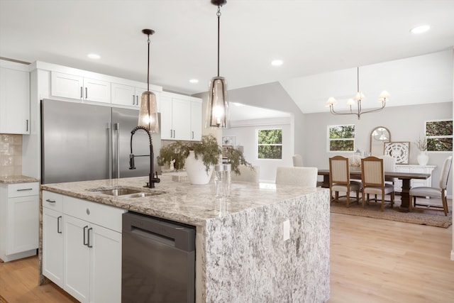 7 Corte De Canoncito, Cedar Crest, NM 87008 - kitchen featuring appliances with stainless steel finishes, light wood-type flooring, decorative backsplash, white cabinetry, and a center island with sink