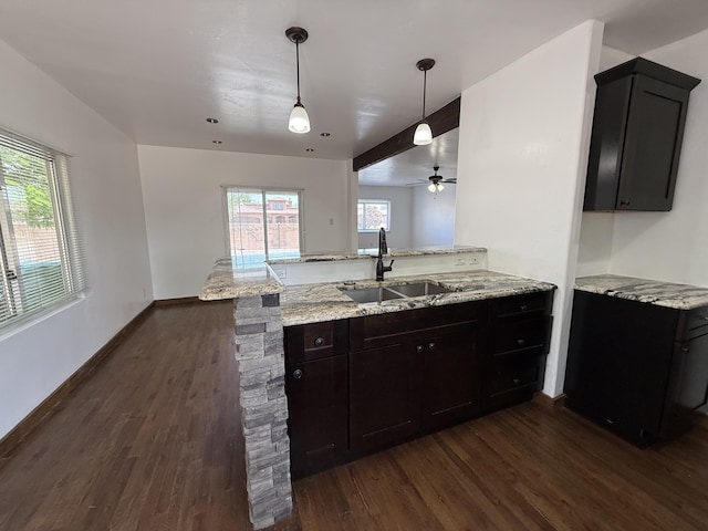 98 Rancho Pequenos Way, Albuquerque, NM 87114 - kitchen featuring dark wood finished floors, a peninsula, light stone countertops, a ceiling fan, and decorative light fixtures