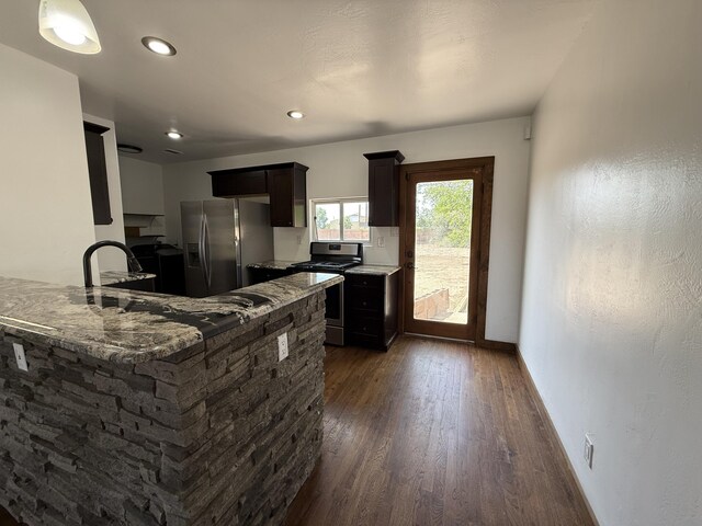 98 Rancho Pequenos Way, Albuquerque, NM 87114 - kitchen with stainless steel appliances, dark wood-type flooring, light stone countertops, a peninsula, and recessed lighting