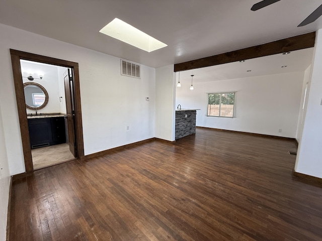 98 Rancho Pequenos Way, Albuquerque, NM 87114 - unfurnished living room with a skylight, dark wood-style flooring, a ceiling fan, and beamed ceiling