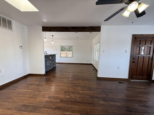 98 Rancho Pequenos Way, Albuquerque, NM 87114 - unfurnished living room featuring dark wood finished floors, a skylight, ceiling fan, and beamed ceiling