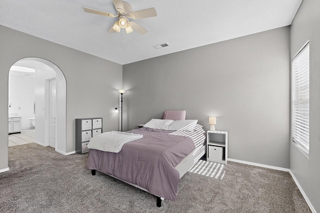 6021 Alamosa Way NW, Albuquerque, NM 87107 - carpeted bedroom with arched walkways, connected bathroom, and ceiling fan